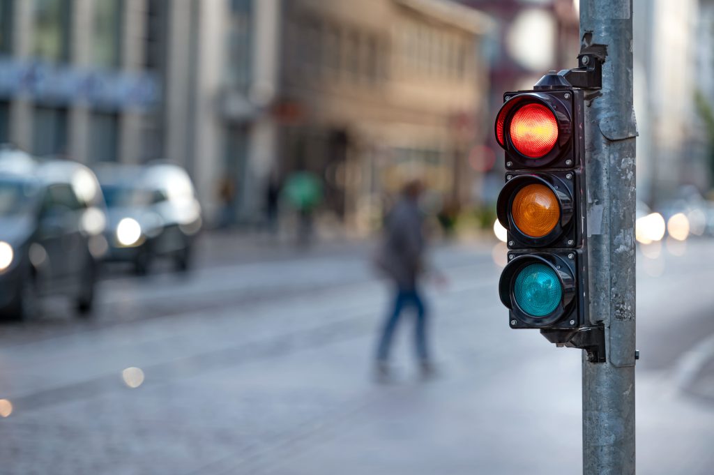 Im Fokus steht eine Ampel, die gerade auf Rot steht.