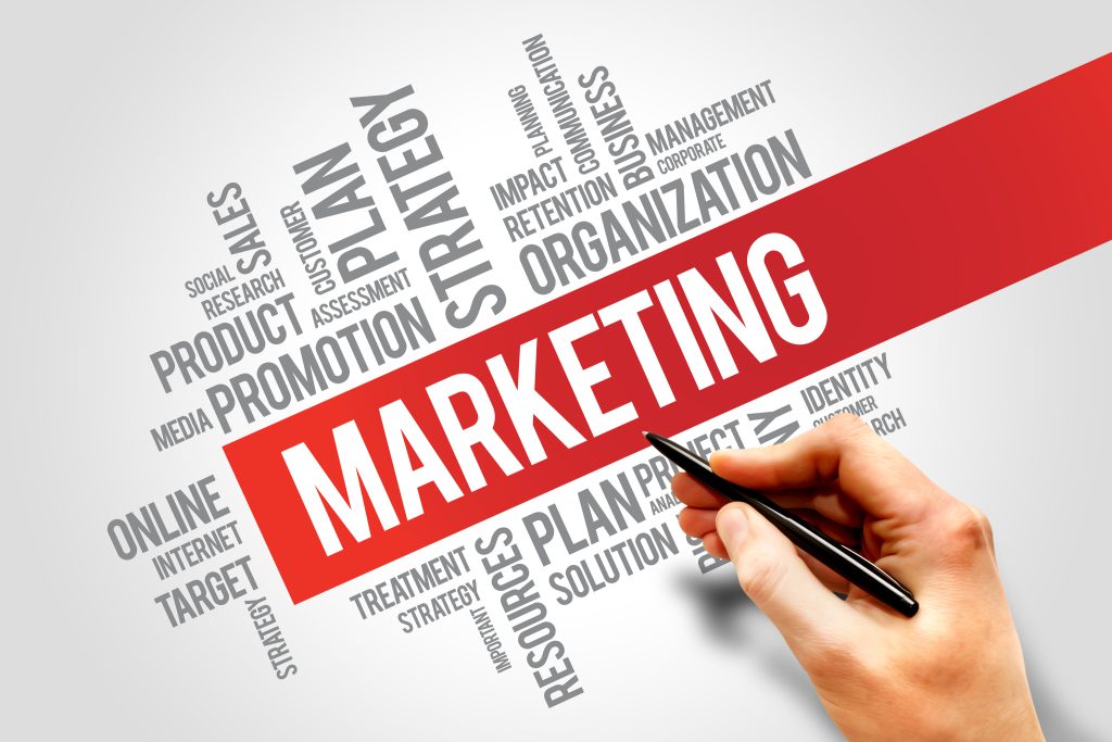 Schriftzug "Marketing" vor rotem Hintergrund mit vielen weiteren Begriffen rundherum