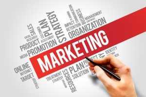 Schriftzug "Marketing" vor rotem Hintergrund mit vielen weiteren Begriffen rundherum